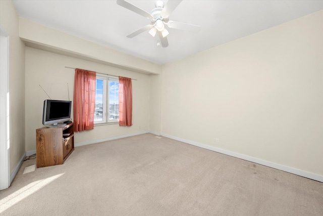 unfurnished living room featuring a ceiling fan, baseboards, and light carpet