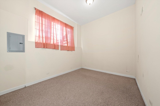 empty room featuring baseboards, electric panel, and carpet flooring