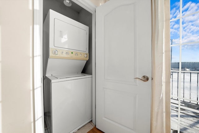 washroom featuring stacked washer and dryer and laundry area