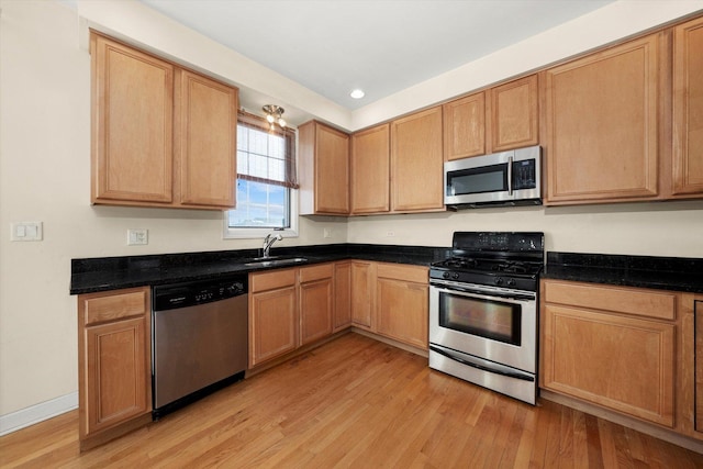 kitchen with recessed lighting, a sink, appliances with stainless steel finishes, and light wood-style floors