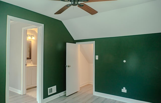 227 E 6th St, Lockport, IL 60441 - unfurnished bedroom featuring light wood finished floors, vaulted ceiling, baseboards, connected bathroom, and ceiling fan
