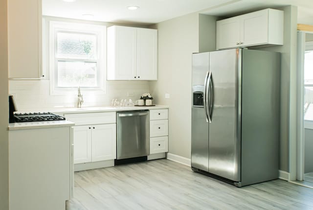 227 E 6th St, Lockport, IL 60441 - kitchen featuring appliances with stainless steel finishes, backsplash, light wood-style floors, white cabinetry, and recessed lighting