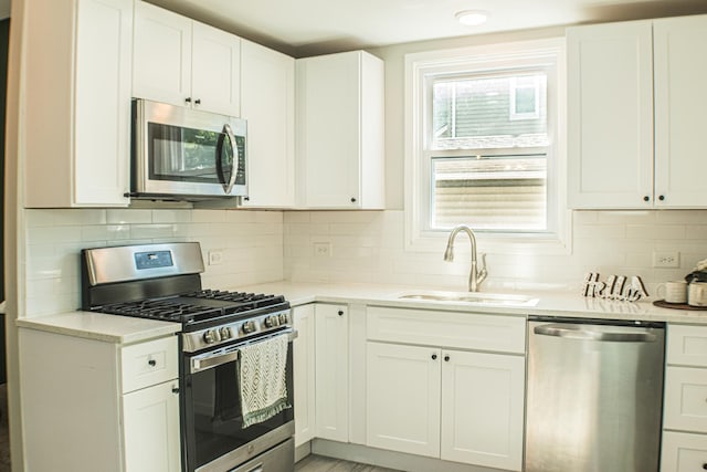 227 E 6th St, Lockport, IL 60441 - kitchen featuring appliances with stainless steel finishes, a sink, light countertops, white cabinetry, and backsplash