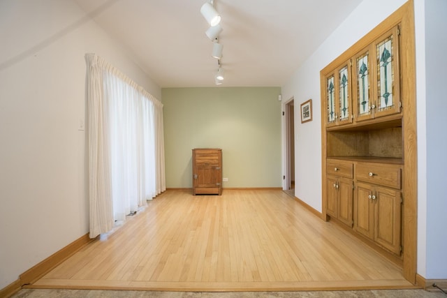 interior space featuring light wood-type flooring and baseboards