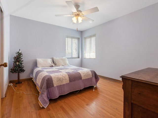 bedroom featuring baseboards, ceiling fan, and light wood-style flooring