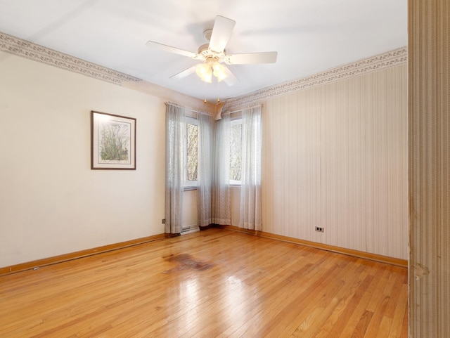 unfurnished room featuring baseboards, a ceiling fan, and light wood-style flooring