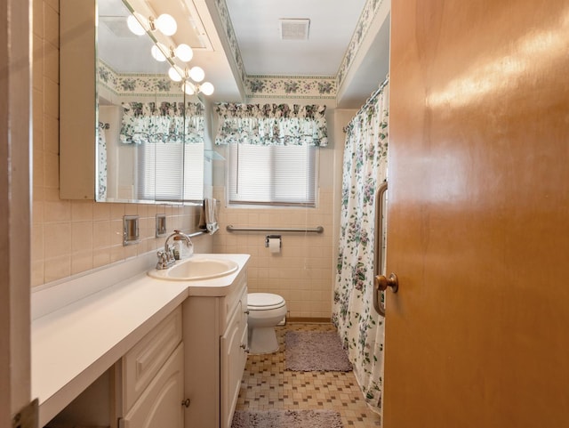 full bathroom featuring a shower with curtain, tile walls, toilet, vanity, and visible vents