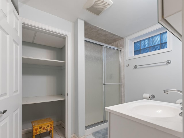 full bathroom with tile patterned floors, visible vents, a shower stall, and a sink