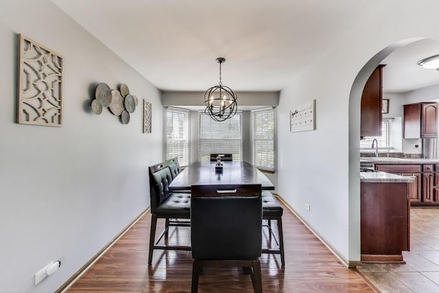 1214 Lone Oak Trl, Aurora, IL 60506 - dining area featuring arched walkways, a chandelier, and wood finished floors