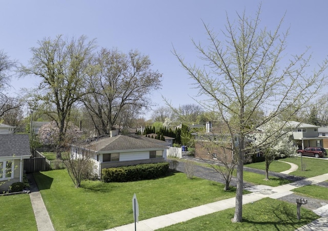 view of community with fence and a yard