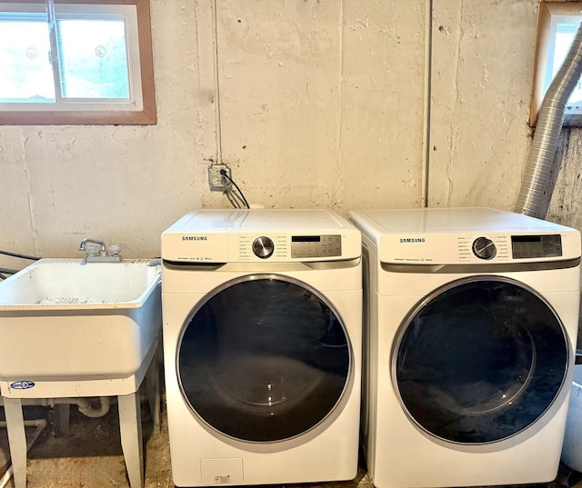 laundry room featuring washer and clothes dryer, laundry area, and a sink