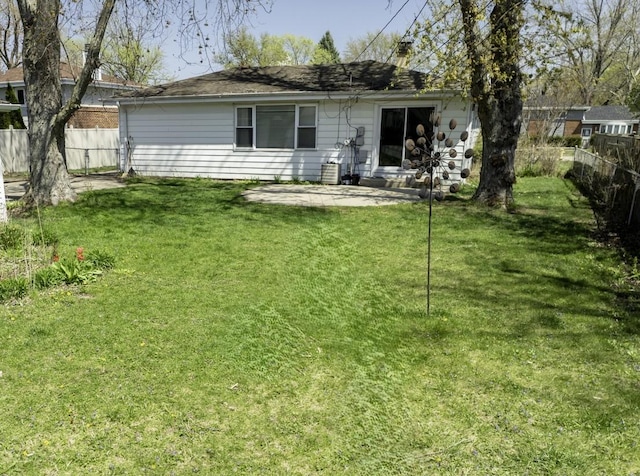 back of house with fence, a yard, and a patio
