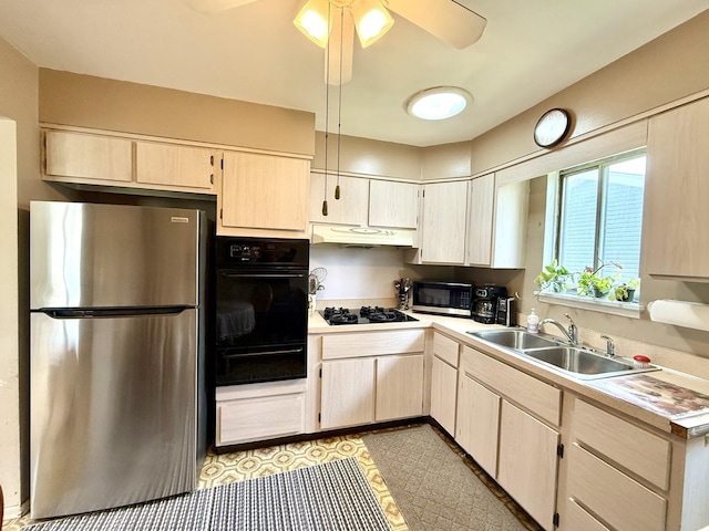 kitchen featuring black appliances, under cabinet range hood, light countertops, and a sink