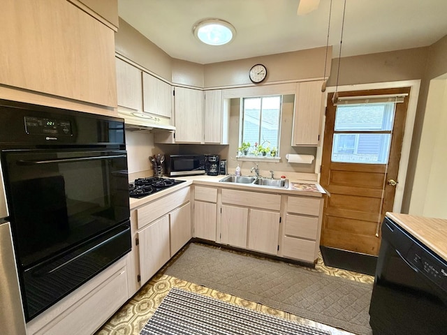 kitchen featuring black appliances, light countertops, under cabinet range hood, and a sink