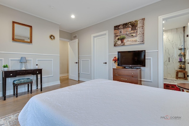 bedroom featuring recessed lighting, wood finished floors, a decorative wall, a wainscoted wall, and crown molding