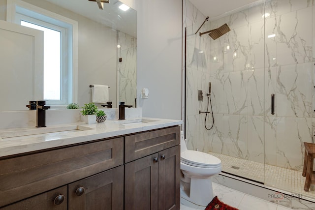 bathroom with a sink, double vanity, a marble finish shower, toilet, and marble finish floor