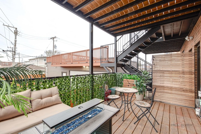 wooden deck with stairway and an outdoor living space with a fire pit