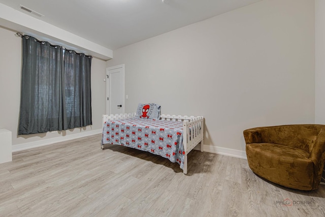 bedroom featuring baseboards, visible vents, and wood finished floors