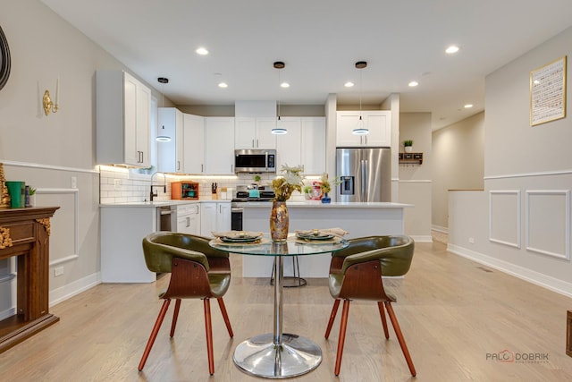 dining area with recessed lighting, light wood finished floors, and baseboards