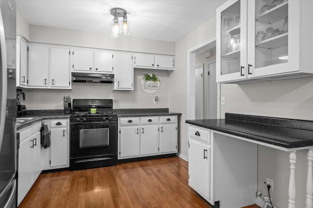 kitchen featuring dark countertops, black range with gas stovetop, dark wood-style floors, under cabinet range hood, and white cabinetry