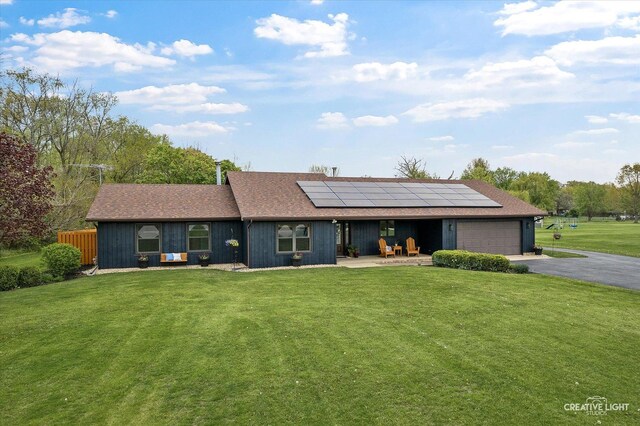 911 E Main St, Plano, IL 60545 - view of front of property featuring an attached garage, driveway, solar panels, a front lawn, and a shingled roof