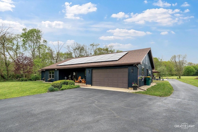 911 E Main St, Plano, IL 60545 - view of front of property with asphalt driveway, an attached garage, roof mounted solar panels, a front lawn, and roof with shingles