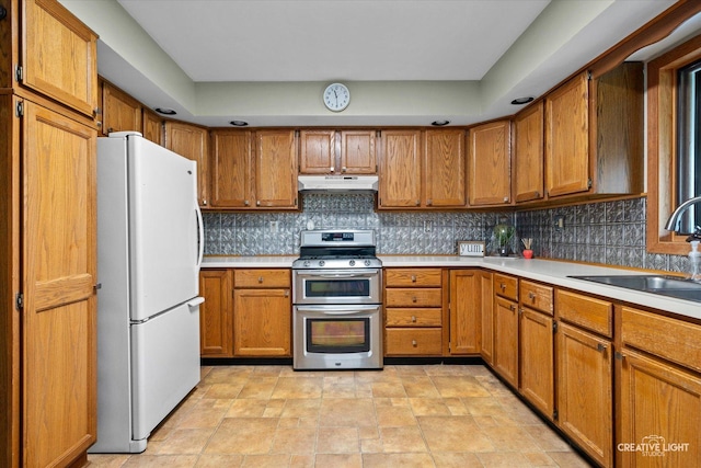 911 E Main St, Plano, IL 60545 - kitchen featuring freestanding refrigerator, range with two ovens, under cabinet range hood, a sink, and brown cabinets