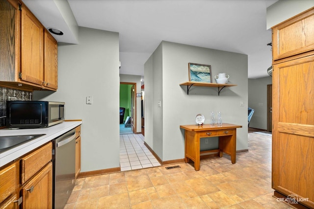 911 E Main St, Plano, IL 60545 - kitchen featuring dishwasher, black microwave, light countertops, baseboards, and brown cabinets