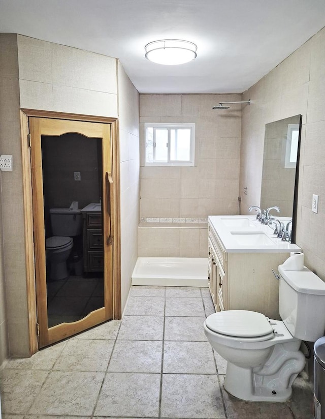 bathroom with vanity, tile patterned floors, toilet, and tiled shower