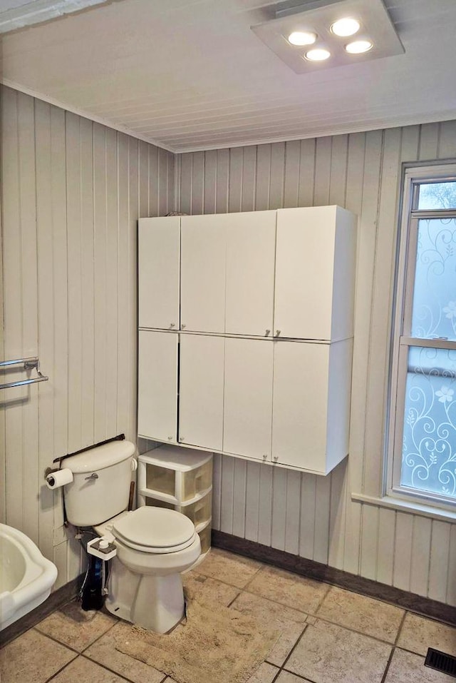 bathroom featuring baseboards, toilet, and visible vents