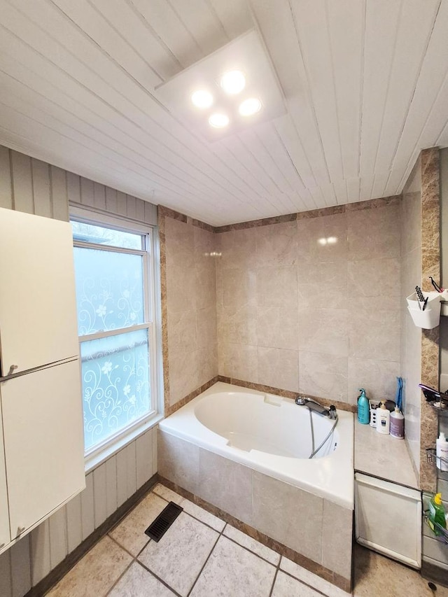 bathroom with tile patterned floors, wood ceiling, and a bath