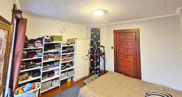 bedroom featuring crown molding and dark wood-style flooring