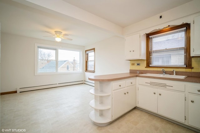 kitchen with a sink, ceiling fan, open shelves, white cabinets, and a baseboard radiator