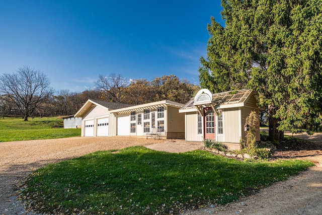 ranch-style house with a garage, a front lawn, and driveway