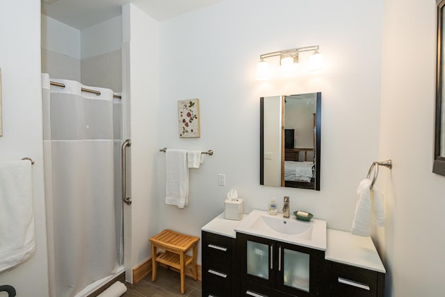 ensuite bathroom with vanity, baseboards, walk in shower, and ensuite bath