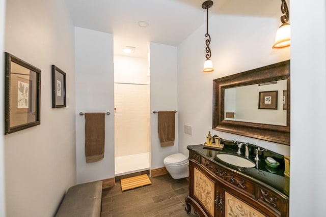 full bathroom featuring walk in shower, wood finish floors, vanity, baseboards, and toilet