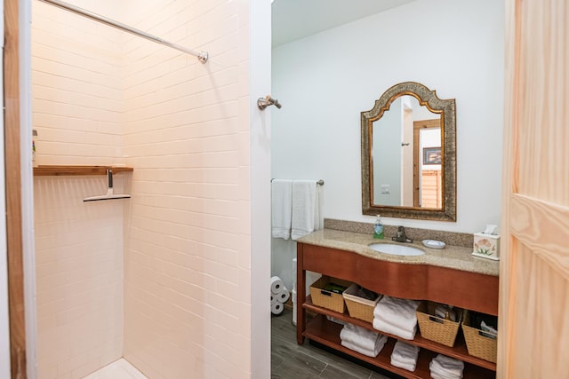 full bathroom with tiled shower and vanity