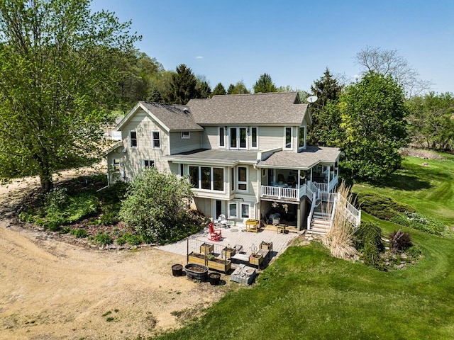 back of house featuring a lawn, a patio, a fire pit, and stairway