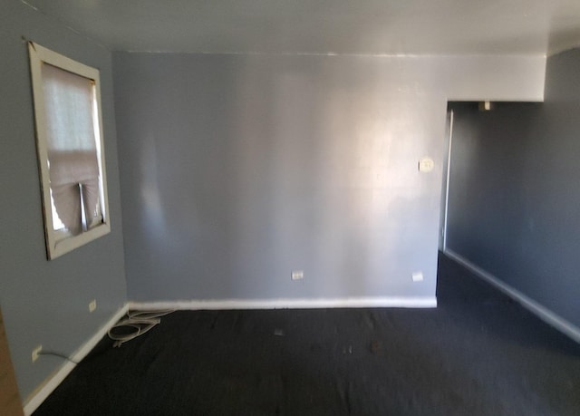 carpeted spare room with baseboards