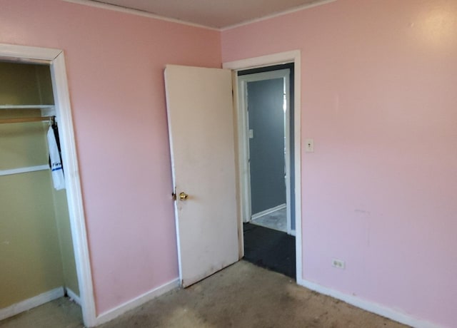 unfurnished bedroom with ornamental molding, carpet flooring, and baseboards