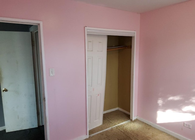 unfurnished bedroom featuring a closet, carpet, and baseboards