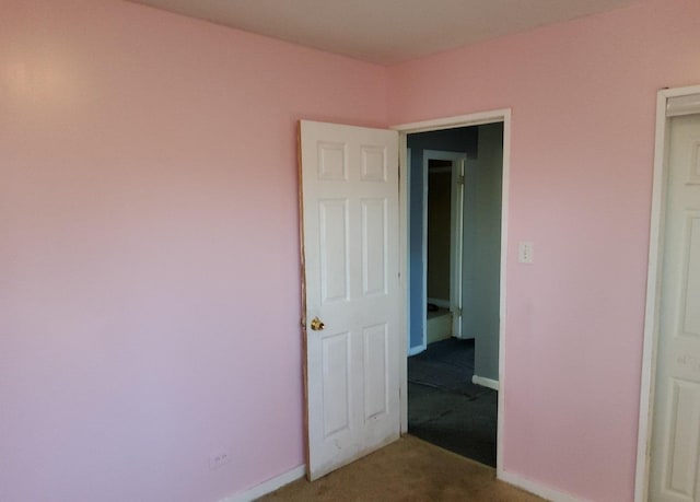 unfurnished bedroom featuring carpet flooring and baseboards