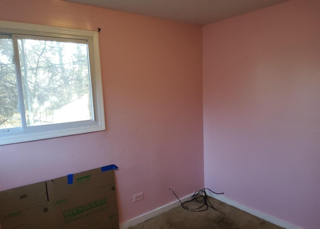 empty room featuring carpet floors, a healthy amount of sunlight, and baseboards
