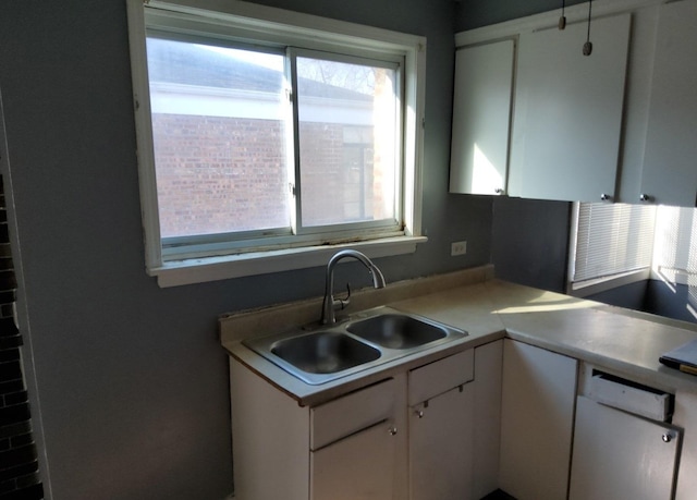 kitchen featuring white cabinetry, a healthy amount of sunlight, and a sink