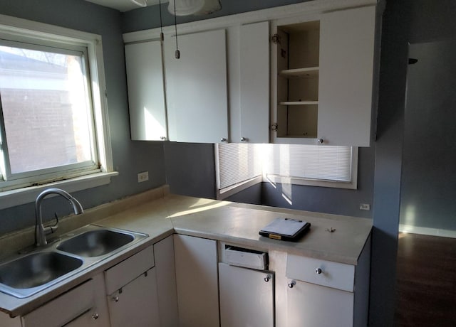 kitchen with a sink, white cabinetry, and light countertops