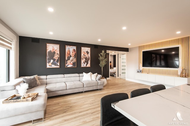 living area with recessed lighting, wood finished floors, and visible vents