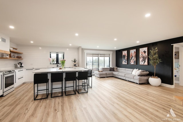 living room with recessed lighting, visible vents, and light wood-style floors