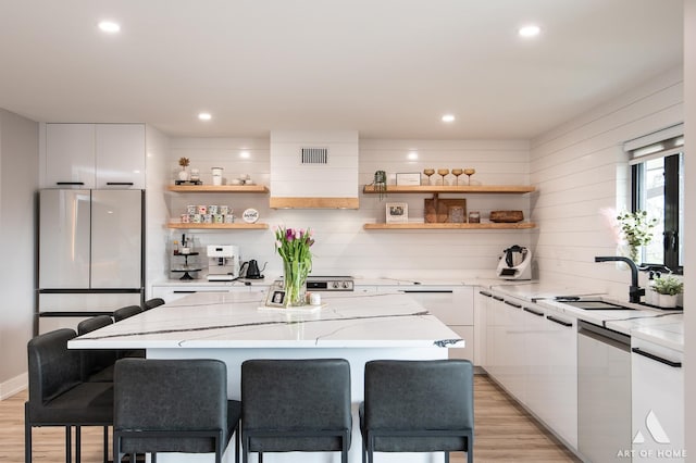 kitchen featuring visible vents, open shelves, white cabinetry, and freestanding refrigerator