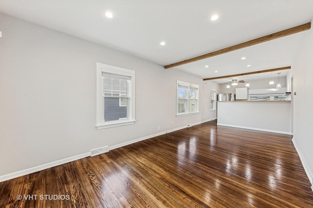 unfurnished living room with beam ceiling, recessed lighting, baseboards, wood finished floors, and visible vents
