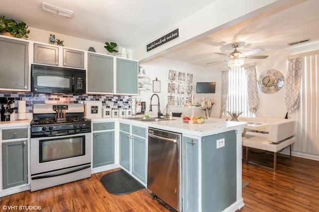 kitchen with stainless steel appliances, light countertops, a sink, visible vents, and a peninsula